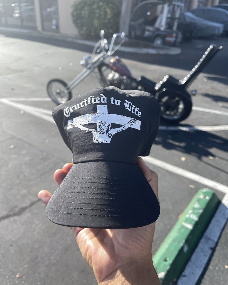Crucified to Life hat, black, in front of a chopper